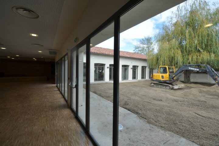 Vue intérieure de la salle polyvalente montrant la modularité pour les spectacles et conférences.