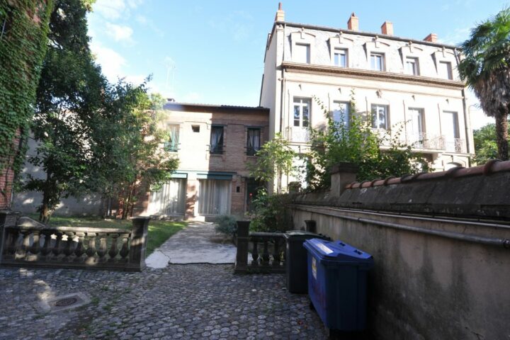 Extension architecturale moderne sur une maison ancienne en briques à Toulouse.