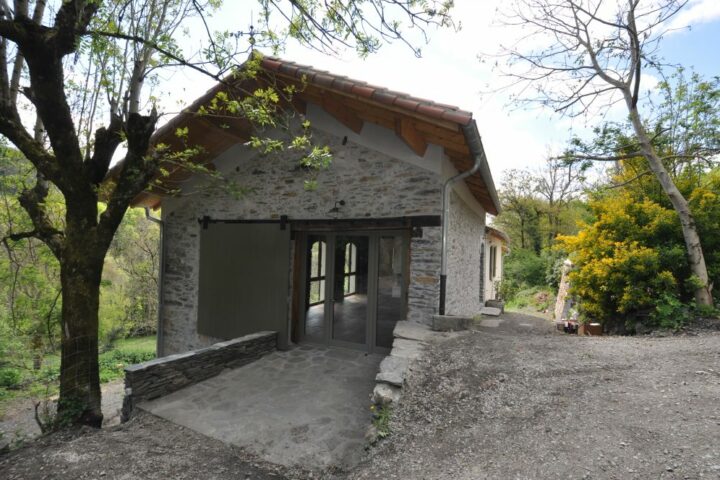 Vue extérieure d'une grange traditionnelle réhabilitée en maison secondaire par AIM Projets.